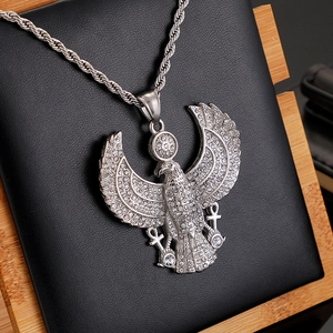 Macro detail of silver Egyptian eagle pendant with sparkling crystals on black leather background