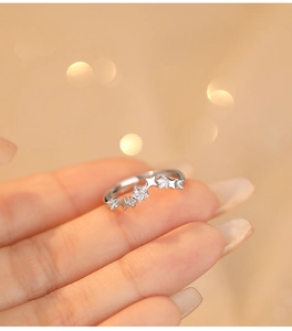 Macro shot of a S925 silver star ring with white zircon on hand with bokeh background