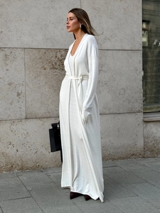 Detail of white knit maxi dress and matching long sleeve cardigan set with waist belt