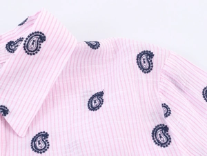 Détail du col d'une chemise à rayures roses avec broderies cachemire bleu marine