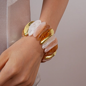 Detail of wide stretch bracelet with marbled resin and metallic pebble links on wrist