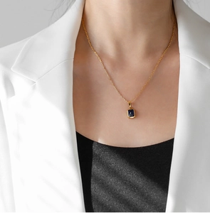 Dettaglio della collana placcata in oro 18K con gemma rettangolare viola su una modella