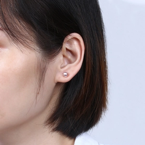 Close-up of elegant lavender freshwater pearl stud earrings worn by a model