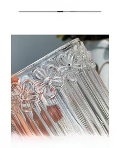 Detailed macro view of the embossed floral patterns and vertical ridges on glass jar