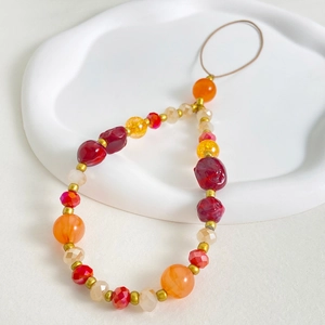 Detailed shot of trendy flower beaded phone strap with colorful resin beads on white tray