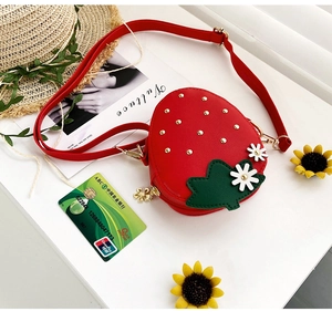 Close-up of strawberry-shaped kids bag with floral accents and adjustable strap