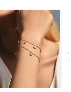 Dettaglio di eleganti bracciali in argento S925 con ciondoli a stella in oro e argento