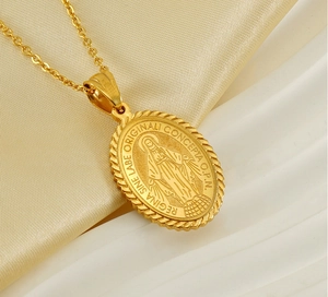 Detail of gold Virgin Mary oval religious pendant with embossed texture and chain