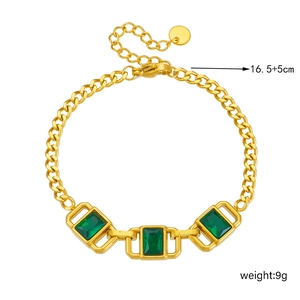 Dettaglio di un bracciale dorato vintage con pietre verdi taglio smeraldo e chiusura a moschettone