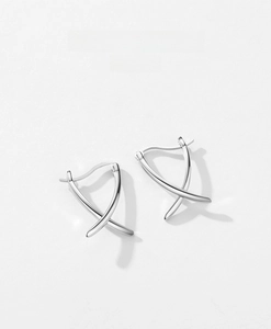Macro detail of S925 sterling silver earrings with a minimalist X-shape cross design