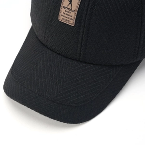 Macro shot of wool baseball cap featuring herringbone texture and leather brand patch