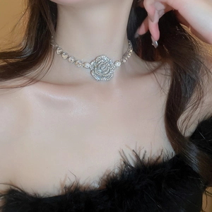 Close-up of a silver floral necklace featuring sparkling crystals on a model's neck