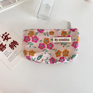 Detail of floral makeup bag with embossed flower patterns and metal zipper closure