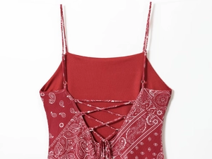 Detail of red paisley print dress featuring backless lace-up design and thin straps