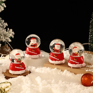 Lot de quatre mini boules à neige Père Noël avec socles en forme de bonnet rouge