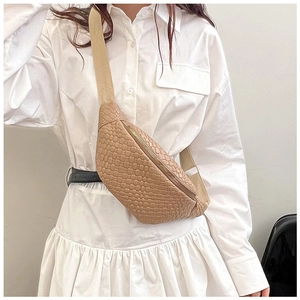 Détail du sac de poitrine tressé abricot avec zip doré et bandoulière réglable