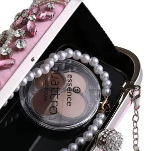 Detail of pink satin clutch bag with rhinestones, pearls and internal storage space