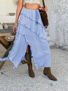 Detail of blue high-slit tiered skirt with ruffle layers and waist tie detail