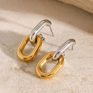 Boucles d'oreilles géométriques bicolores polies en or et argent sur fond de pierre