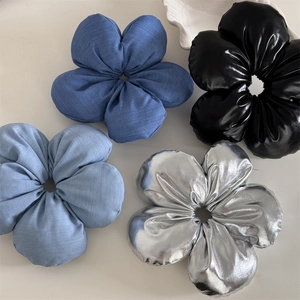 Detailed view of four 3D floral scrunchies in blue, black and silver fabric and glossy finishes