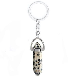 Detail of natural beige spotted stone hexagonal pendant with silver metal keychain