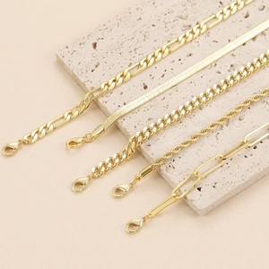 Detail of five assorted gold-plated titanium steel chains including Cuban and paperclip styles