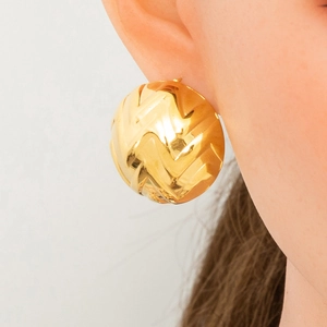 Macro shot of gold-plated stainless steel star half-round earring with wave texture