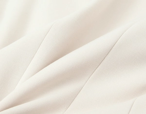 Primo piano della trama del tessuto intrecciato crema con drappeggio naturale e qualità
