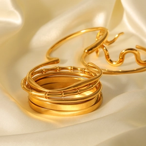 Detail of 18K gold plated stainless steel bangles with bamboo and wave designs