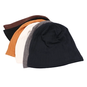 Close-up of stacked ribbed knit beanies showing texture in five various colors