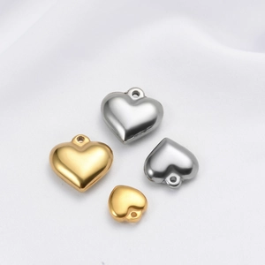 Detailed view of polished heart-shaped pendants in gold and silver finish for DIY jewelry