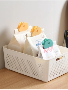 Cloud-shaped food sealing clips in yellow and green used on snack bags in a bin