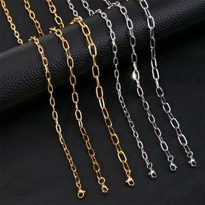 Detailed view of gold and silver rectangle link chains with lobster clasps on black leather