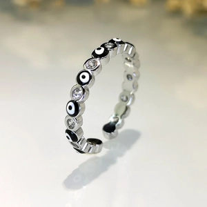 Macro view of silver evil eye ring with alternating enamel eyes and zircon stones
