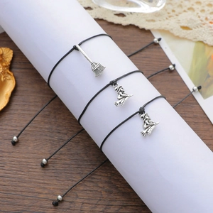 Detail view of Halloween Best Witches card bracelets with broom and witch charms