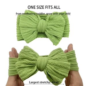 Detail of light green knit baby headband showing high elasticity and size specifications