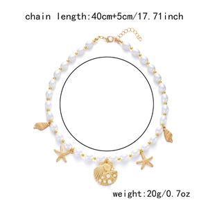 Detail view of pearl and gold chain necklace with shell charms and starfish pendants
