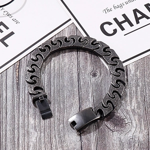 Detail of vintage gunmetal S-link steel bracelet with industrial matte finish texture
