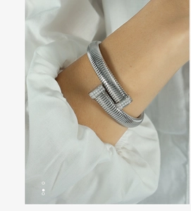 Detailed close-up of a silver nail-shaped bracelet with shimmering pave set zircon accents