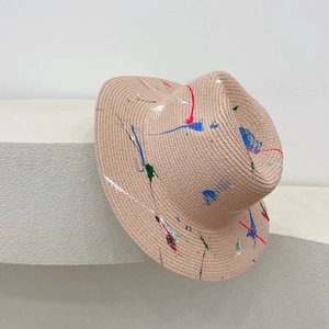Detailed texture of handmade straw hat with artistic colorful paint splatter design