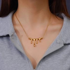Lava liquid teardrop necklace in 18k gold plated titanium steel worn by a model