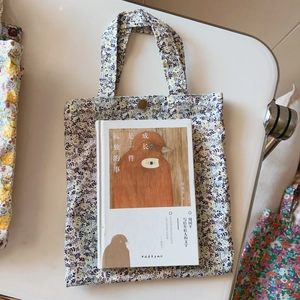 Close-up of floral cotton tote bag featuring blue-yellow pattern and metal snap button
