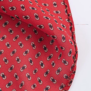 Détail d'un tissu rouge à motifs géométriques et texture de nœud papillon