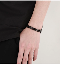 Detail of 9mm matte black Cuban link chain bracelet worn on wrist for men hip hop style