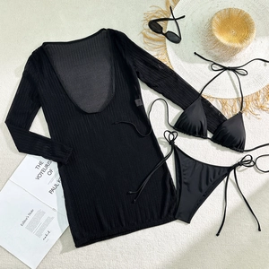 Detailed flat lay of black three-piece bikini set with long sleeve mesh cover-up and straw hat