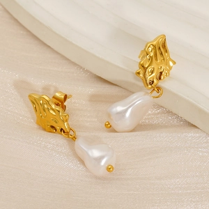 Elegant drop earrings featuring baroque pearls and gold lava-textured metal discs