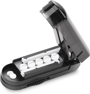 Detail view of the internal V-slot and blade on a portable black pill splitter