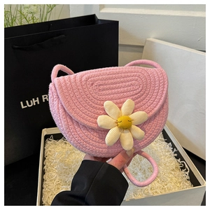 Dettaglio della borsa a sella intrecciata rosa con margherite 3D e trama in corda di cotone