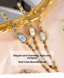 Detailed view of vintage gold oval watches with blue, white, and cream dials on satin