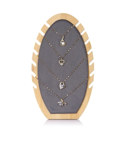 Bamboo necklace display stand featuring grey velvet panel and four gold pendant styles